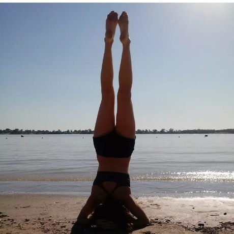 Mariana Camurati en postura de Sirsasana en la playa